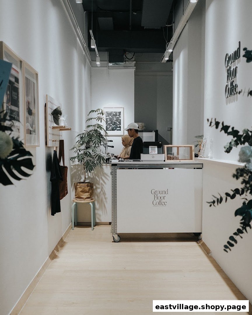 Interior view of Ground Floor Coffee, featuring the minimalist counter and staff preparing drinks.
