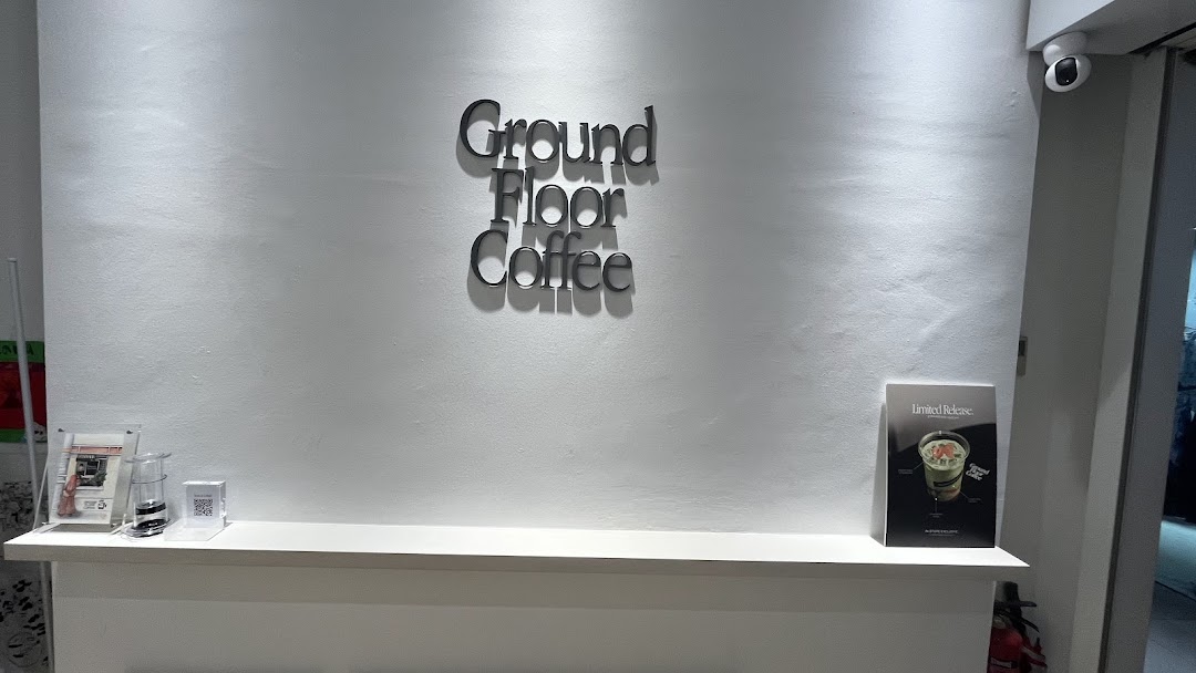 Interior view of Ground Floor Coffee featuring its prominent wall-mounted logo and a clean counter.