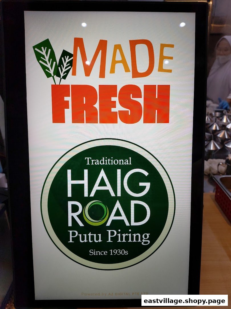 A digital display board for Haig Road Putu Piring, highlighting 'Made Fresh' and its traditional heritage.