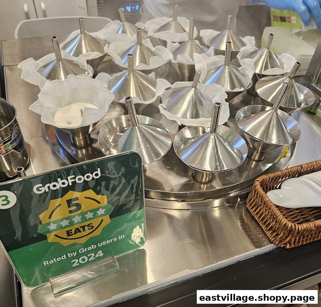 Close-up of putu piring molds with batter, ready for steaming, alongside a GrabFood 5-star rating sign.