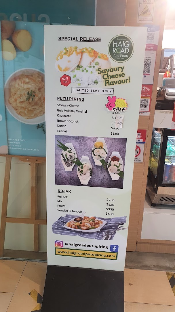 A promotional standee displaying the menu and special offers for Haig Road Putu Piring.