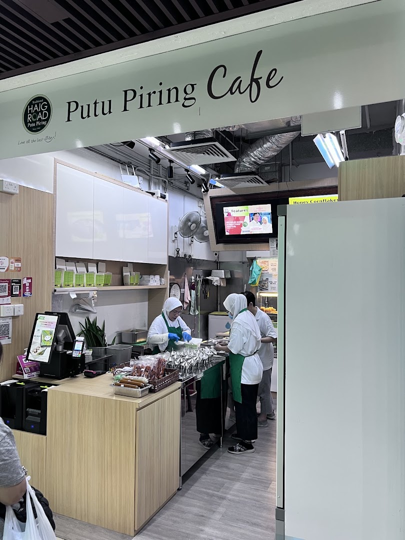 Staff preparing traditional Putu Piring snacks inside the Haig Road Putu Piring Cafe.