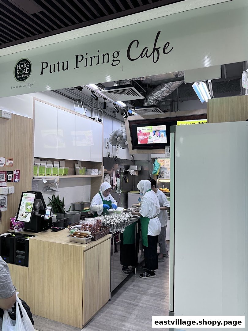 Staff preparing traditional Putu Piring snacks inside the Haig Road Putu Piring Cafe.