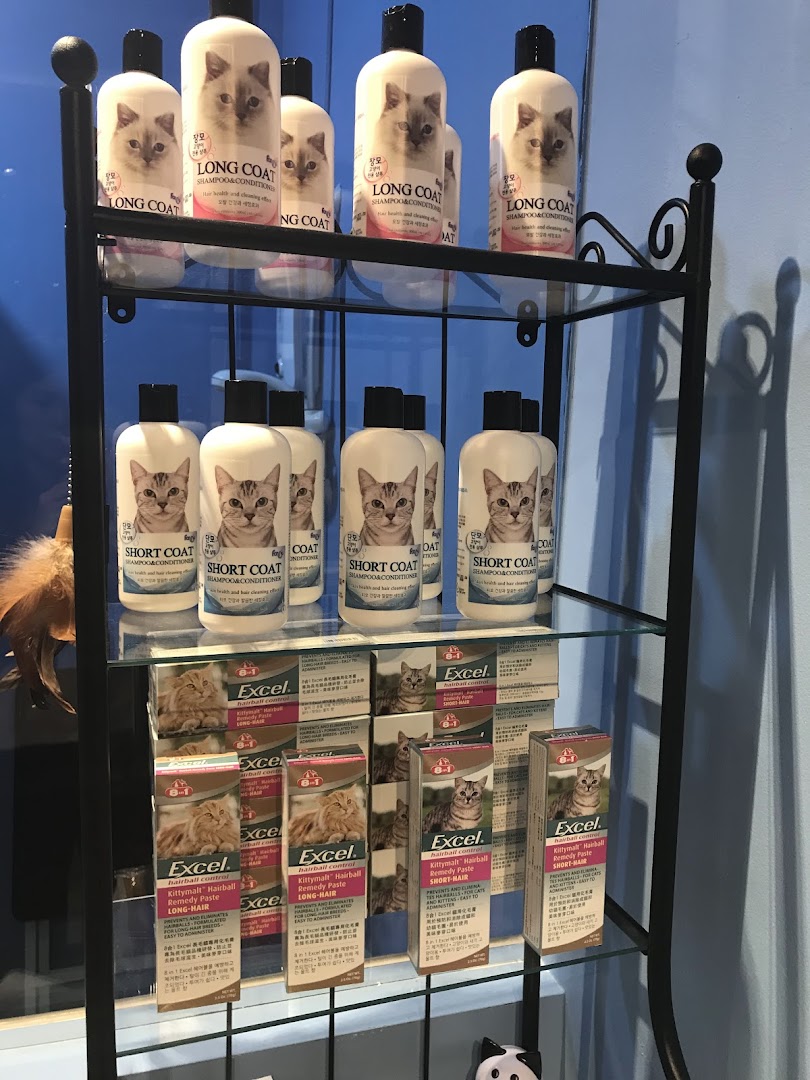 A display shelf showcasing various cat shampoos and hairball remedy pastes for long and short-haired cats.