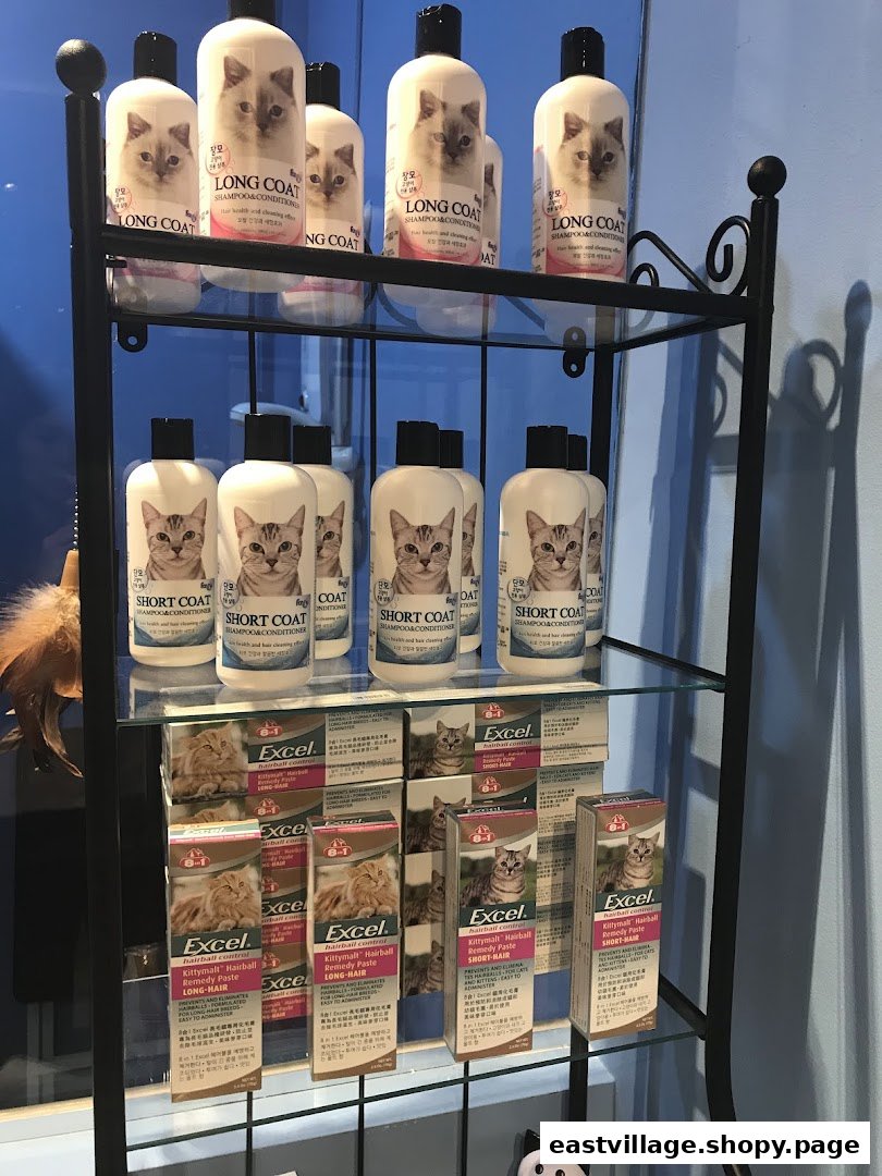 A display shelf showcasing various cat shampoos and hairball remedy pastes for long and short-haired cats.