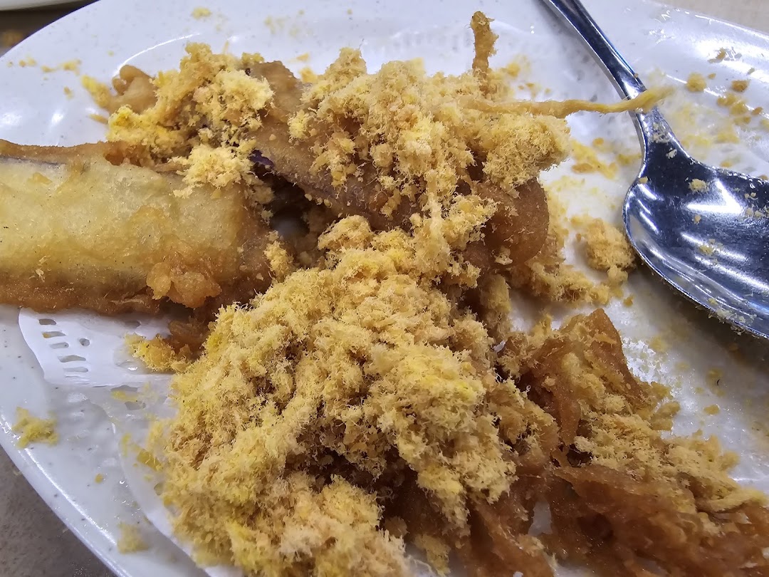 Close-up of crispy fried food topped with a generous amount of golden floss.