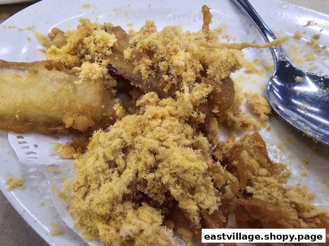 Close-up of crispy fried food topped with a generous amount of golden floss.