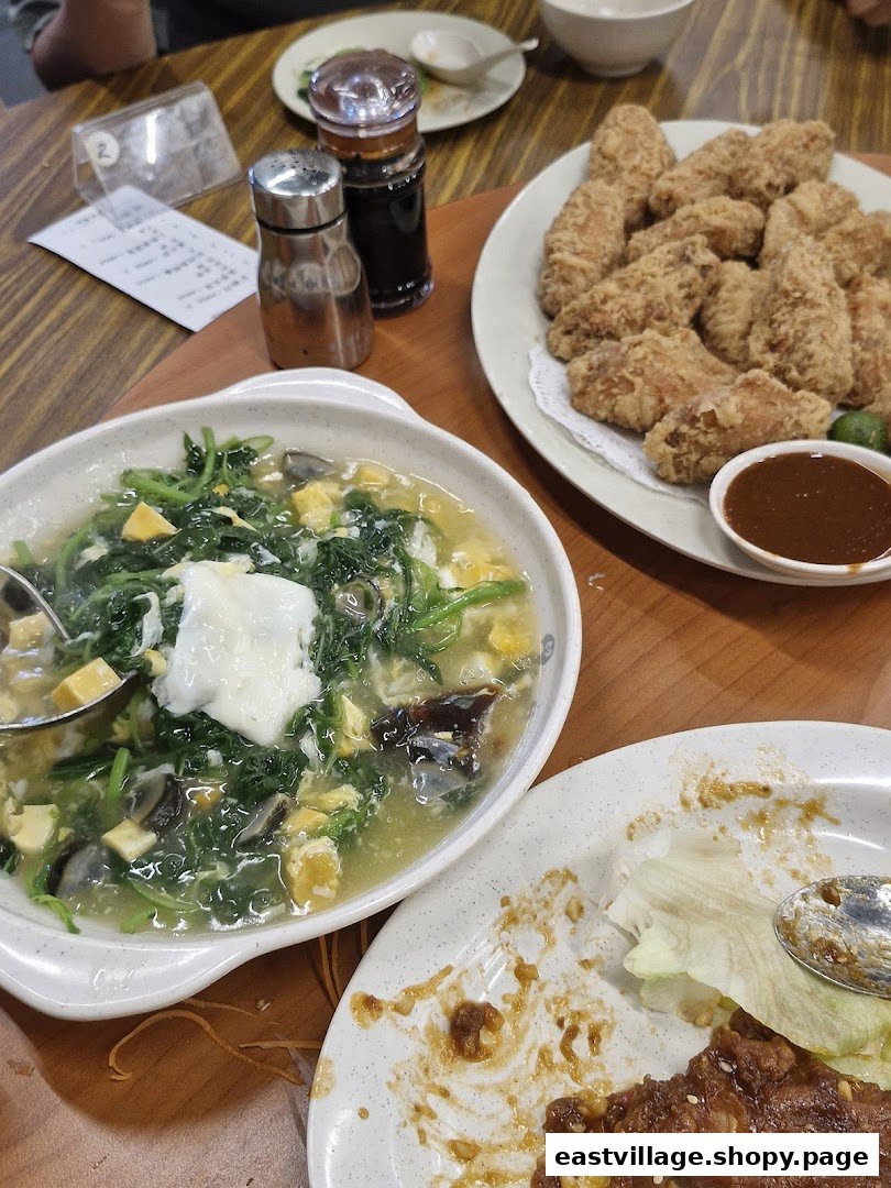 A table laden with delicious fried chicken wings, a hearty vegetable soup, and other dishes.