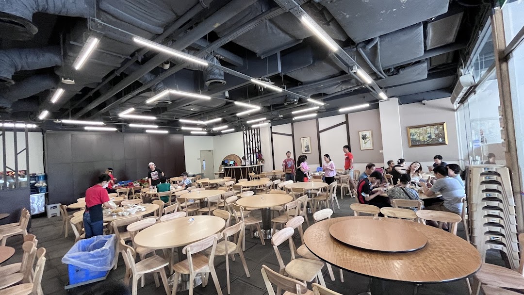 A spacious interior view of Hong Kong Street Family Restaurant, showing diners enjoying meals and staff attending tables.