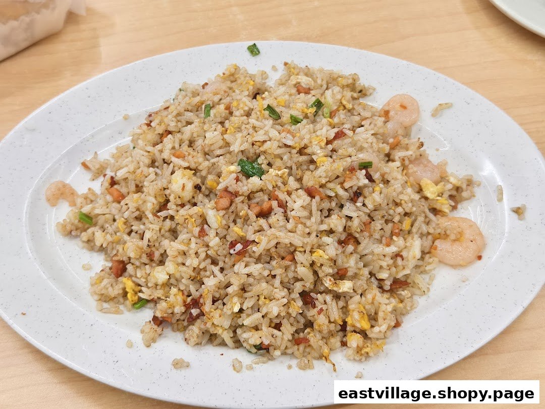 A close-up of a plate of Hong Kong-style fried rice with shrimp, egg, and char siu.