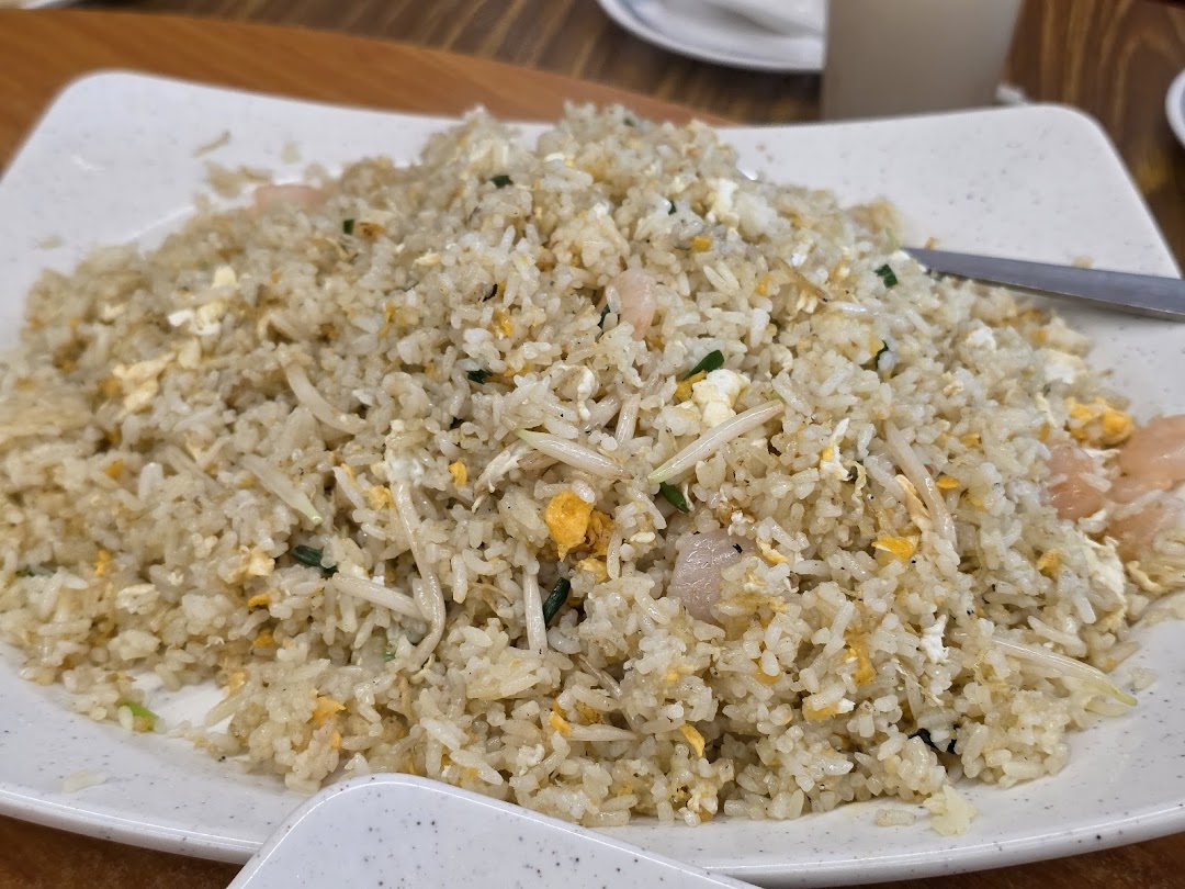 A large plate of delicious fried rice with shrimp, egg, and bean sprouts.