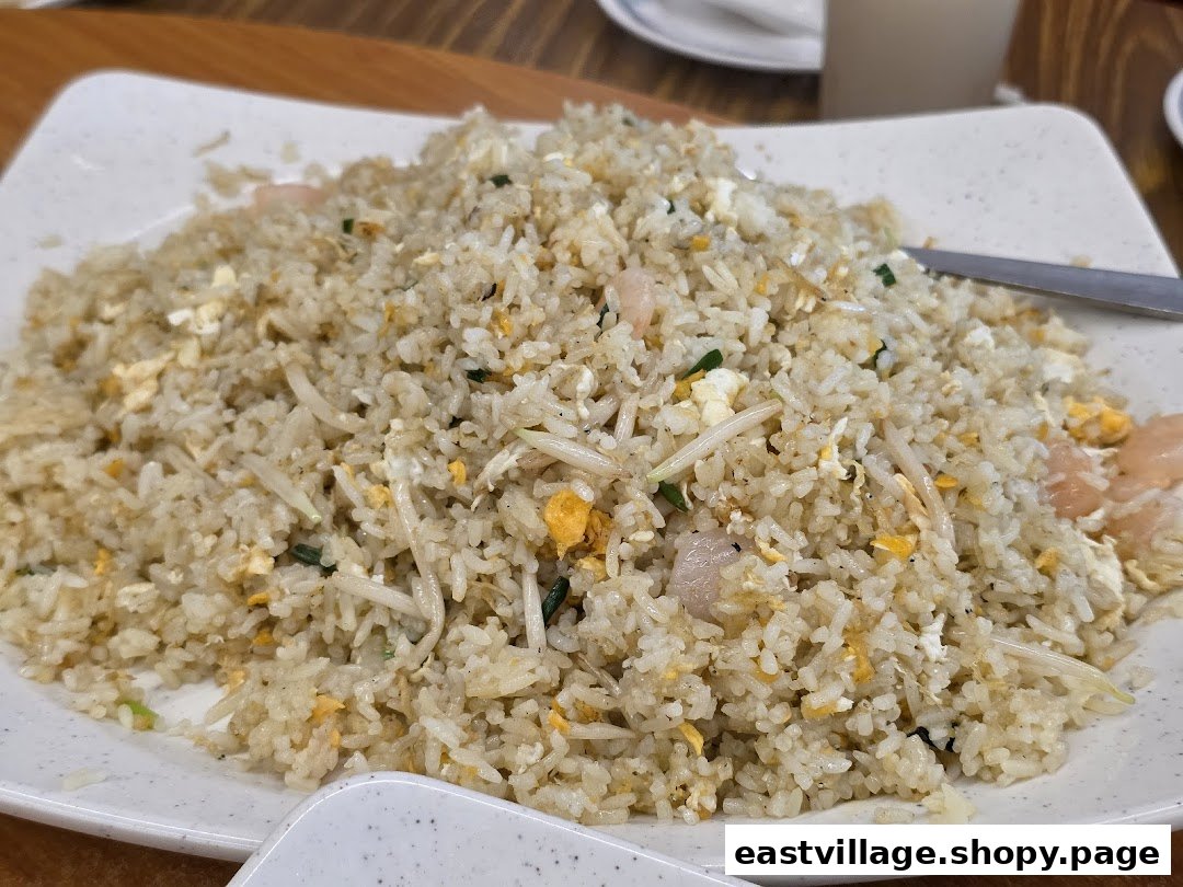 A large plate of delicious fried rice with shrimp, egg, and bean sprouts.
