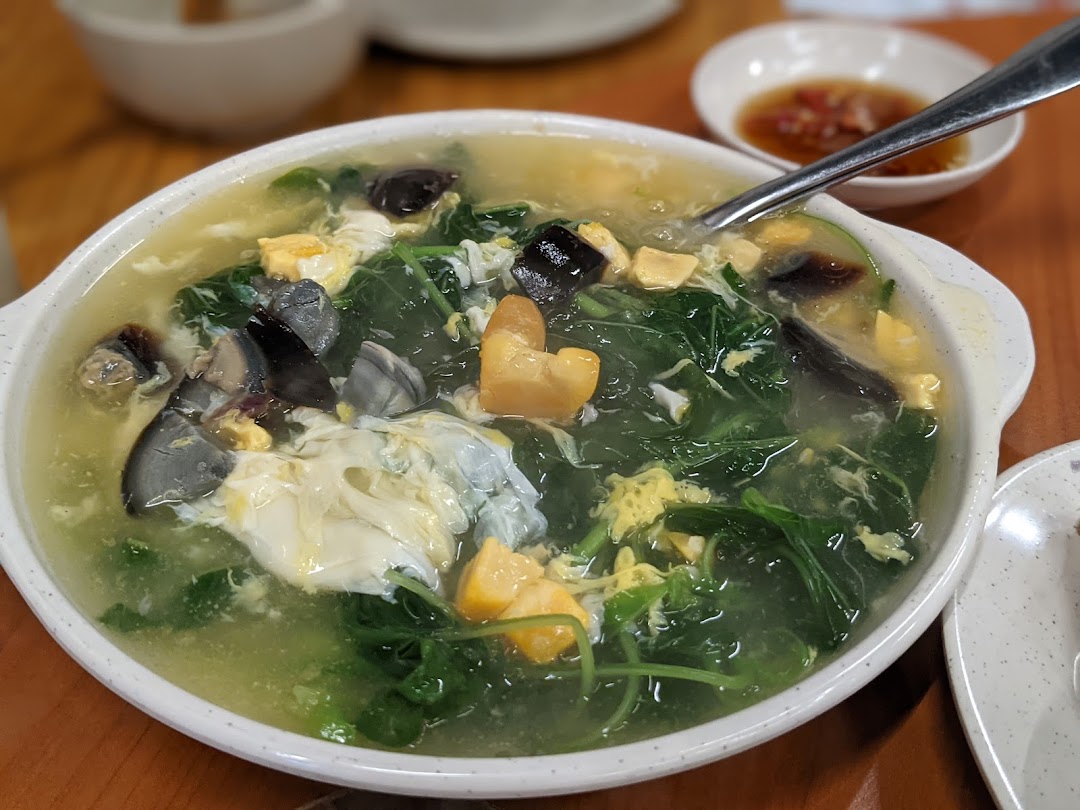 A hearty bowl of spinach soup with century eggs, salted egg, and regular egg.
