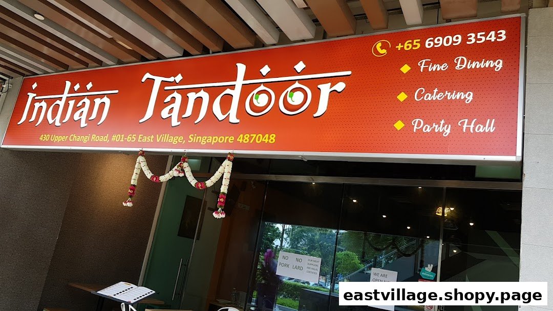 The image displays the vibrant red signboard and entrance of Indian Tandoor Restaurant, featuring contact and service details.