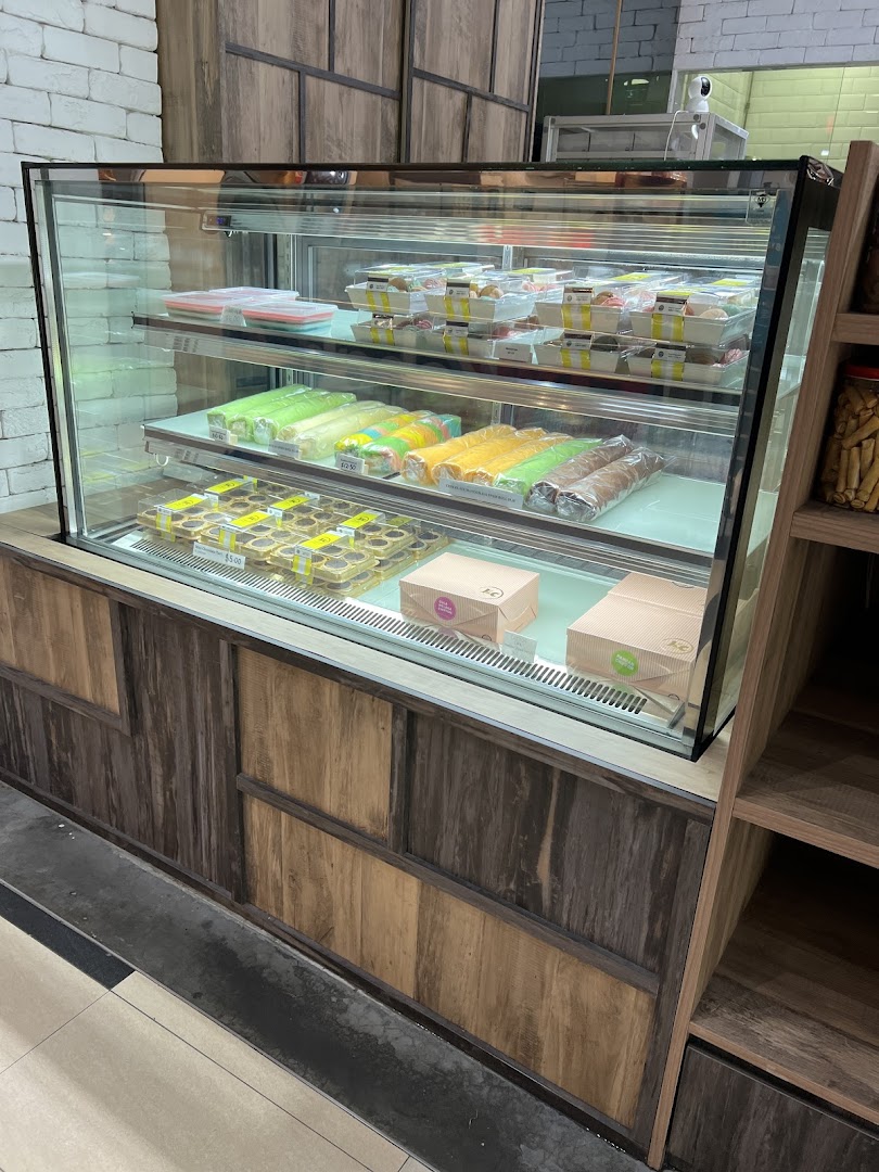 A refrigerated display case showcasing a variety of fresh pastries, cakes, and baked goods at J C Bakery.