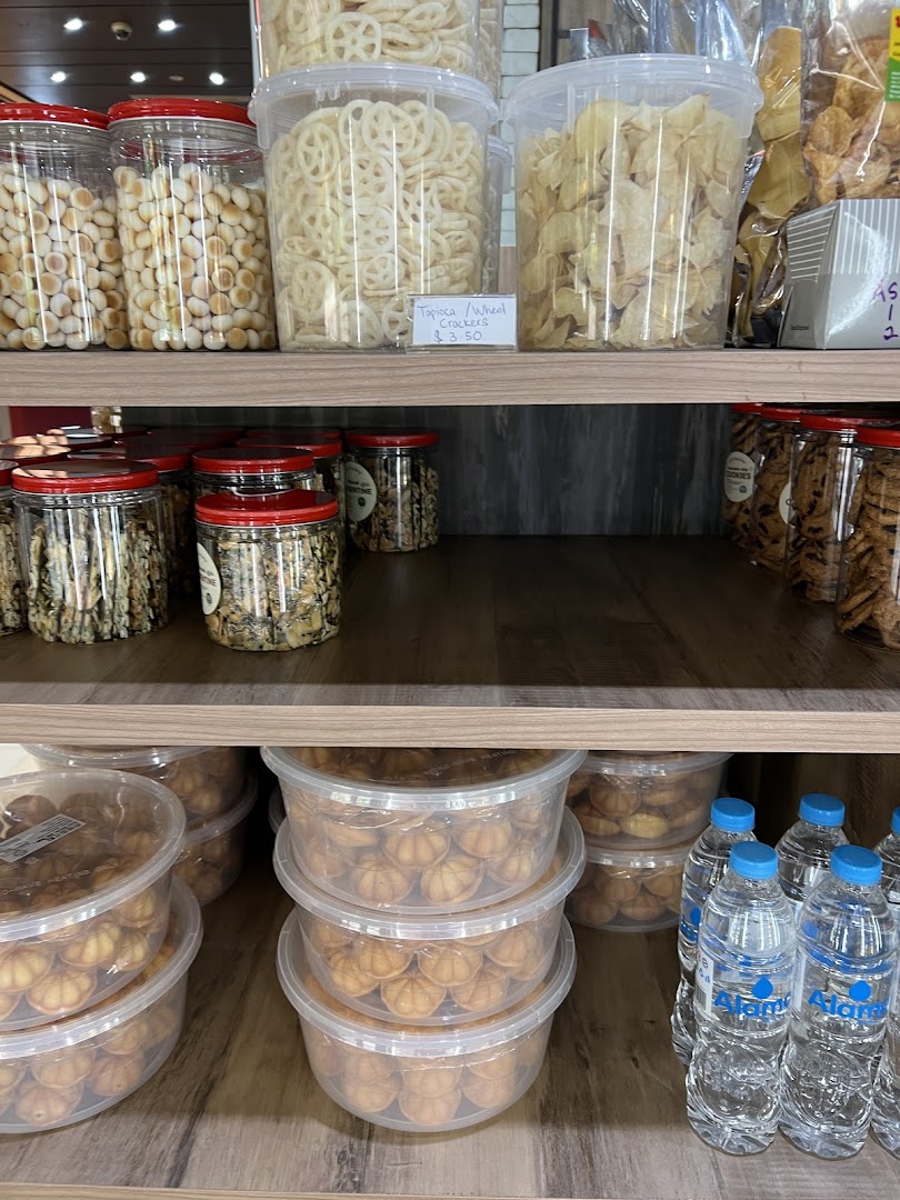 Shelves filled with various packaged snacks, cookies, and crackers in clear containers.