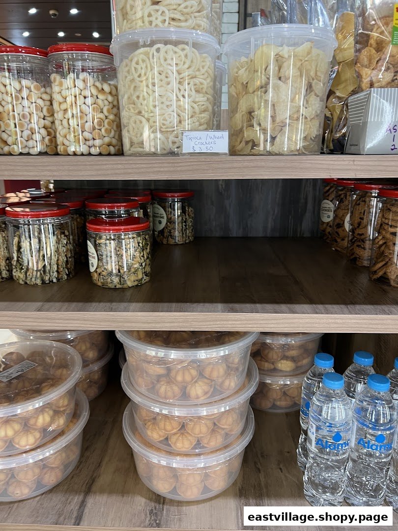 Shelves filled with various packaged snacks, cookies, and crackers in clear containers.