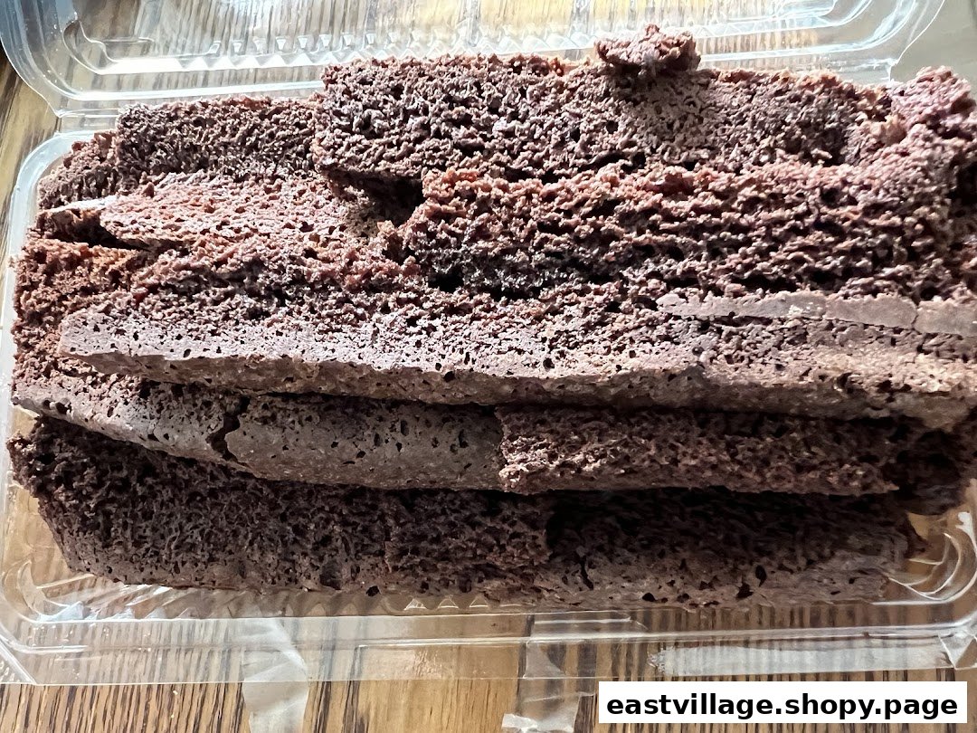 Close-up of several slices of rich chocolate cake or brownie in a clear plastic container.