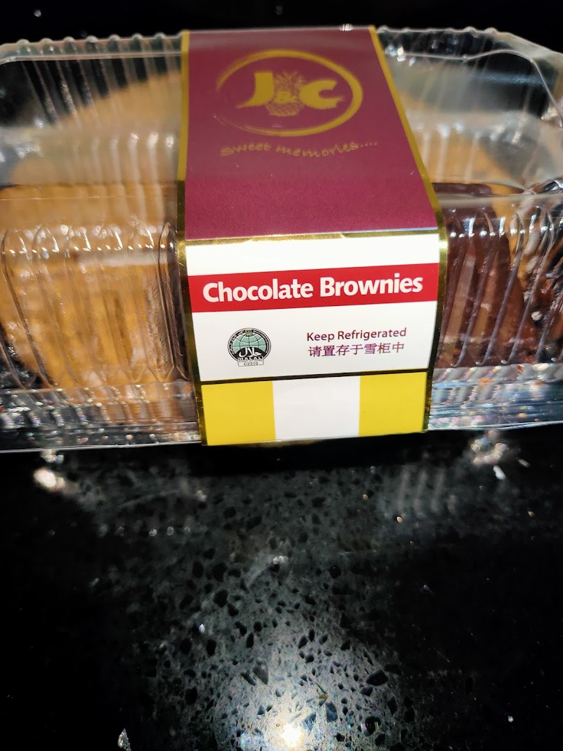 A clear plastic container of J C Bakery chocolate brownies with a branded label.