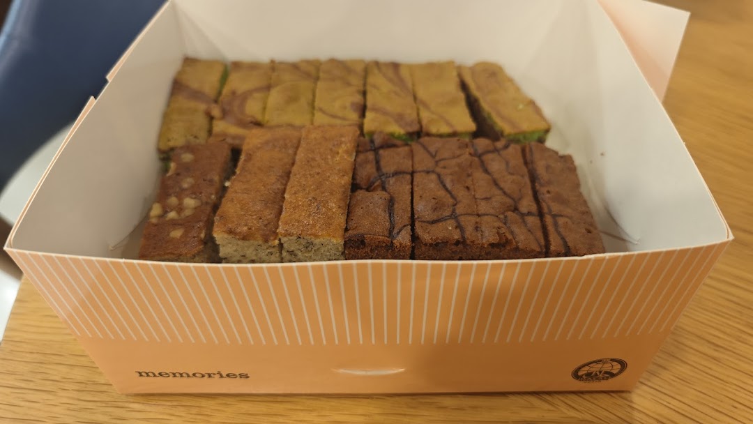 A box filled with various types of sliced baked goods, including brownies and cakes.