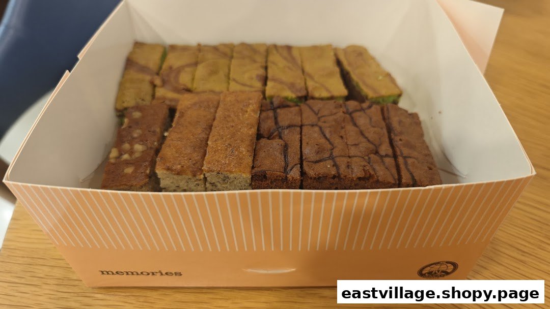 A box filled with various types of sliced baked goods, including brownies and cakes.