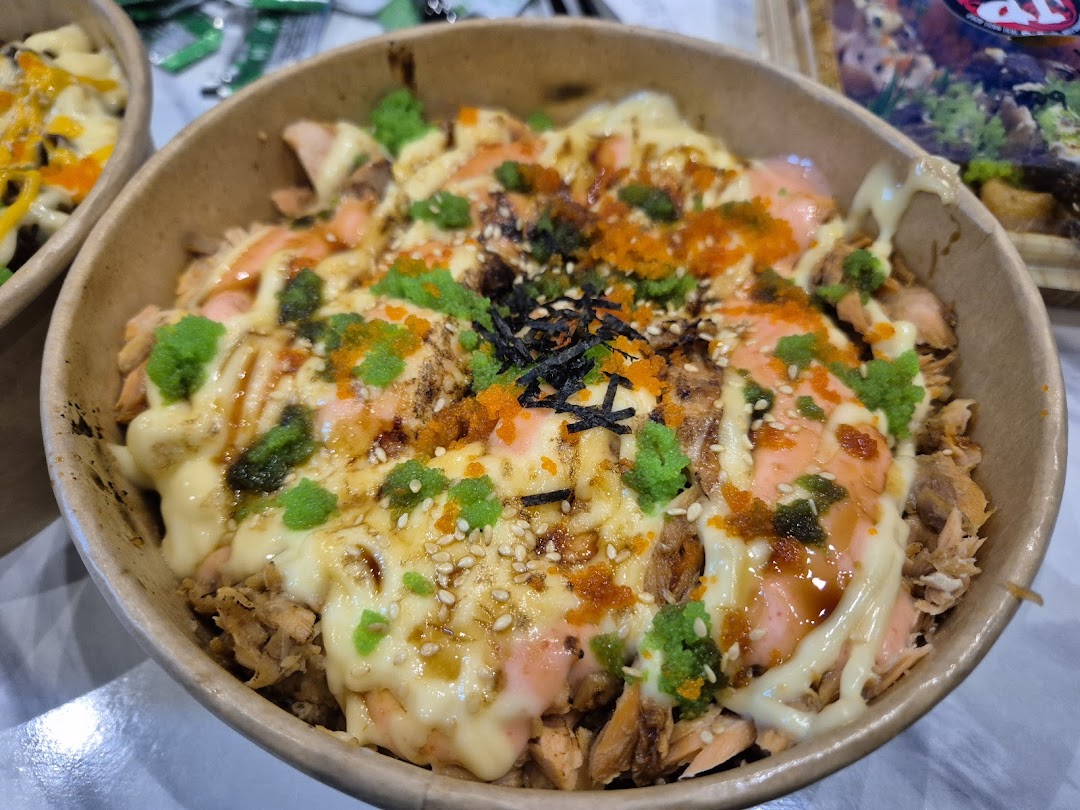 A close-up of a delicious salmon donburi bowl with various toppings from JP Kitchen.
