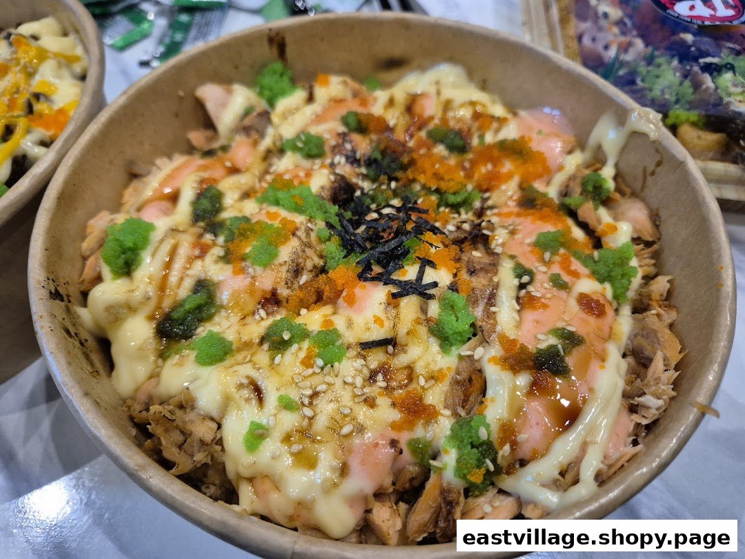 A close-up of a delicious salmon donburi bowl with various toppings from JP Kitchen.