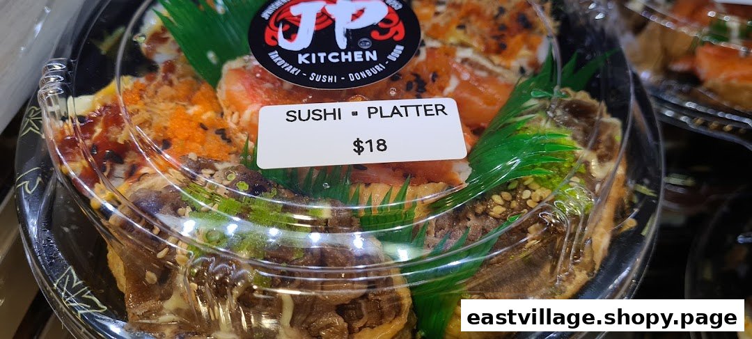 A close-up of a JP Kitchen sushi platter in a clear container with a price tag.