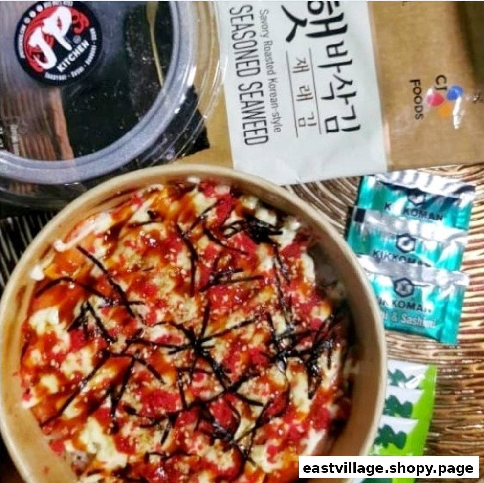 A close-up of a delicious-looking food bowl with toppings, alongside seasoned seaweed and soy sauce packets.