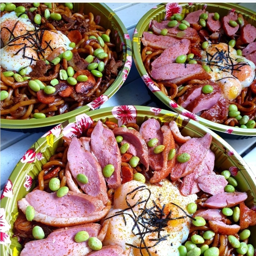 Three bowls of delicious noodles topped with sliced meat, fried eggs, and edamame beans.