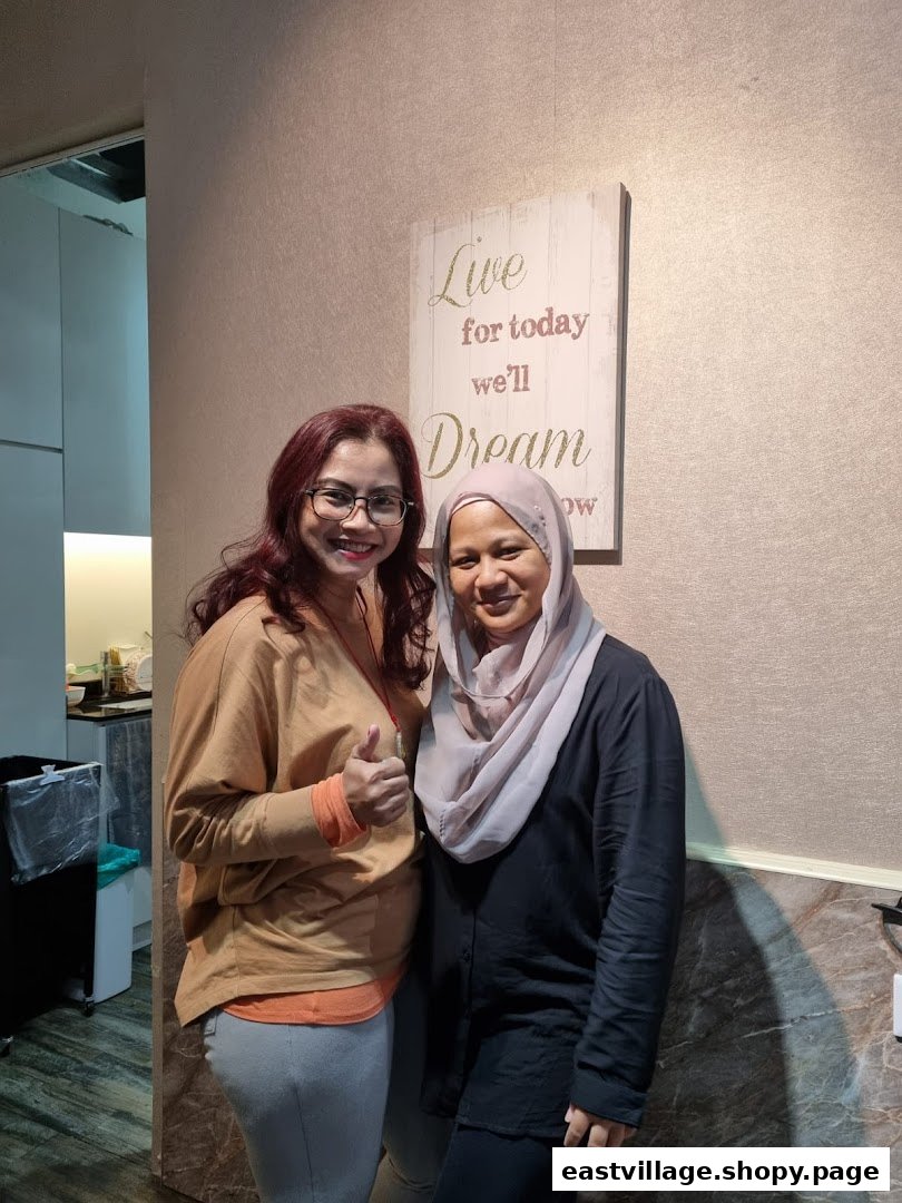 Two smiling women, one giving a thumbs up, inside KARVA Salon for Ladies with a motivational sign.