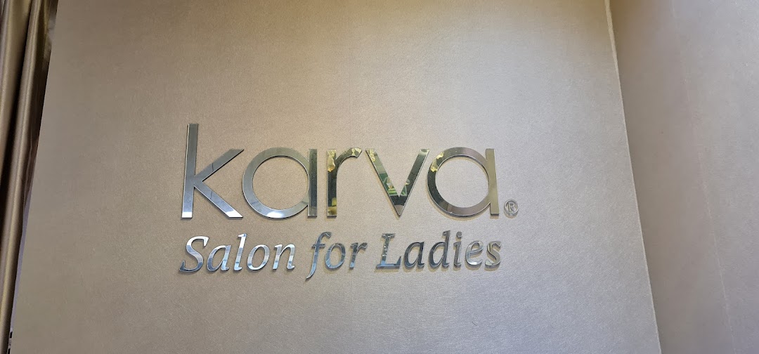 The image displays the elegant 'KARVA Salon for Ladies' signage on a textured wall.