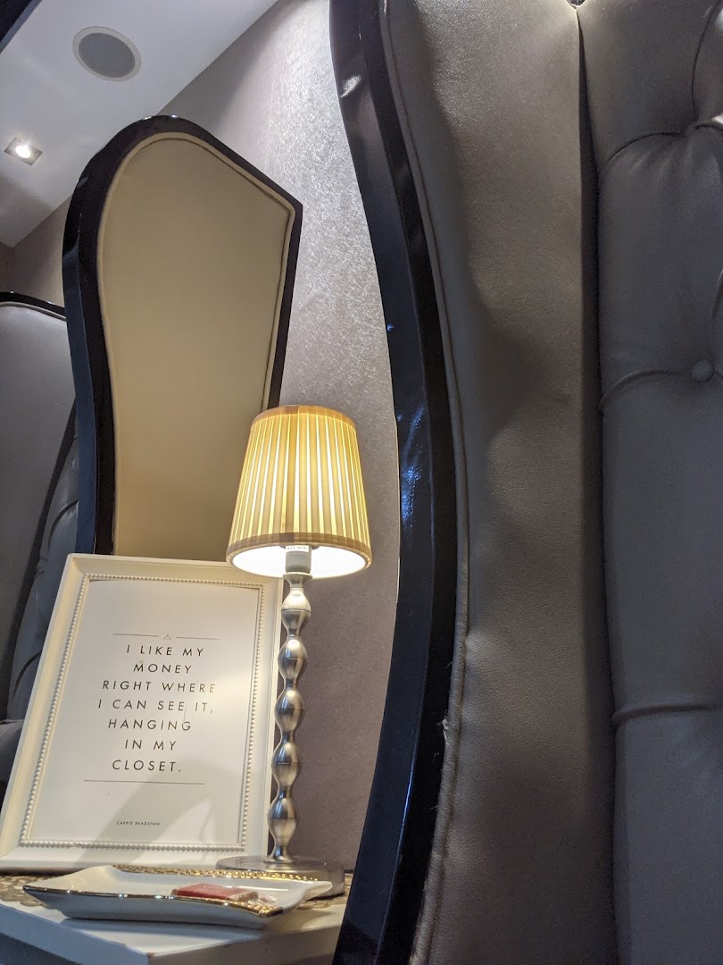 A stylish interior detail featuring a framed quote, a lamp, and elegant salon seating.