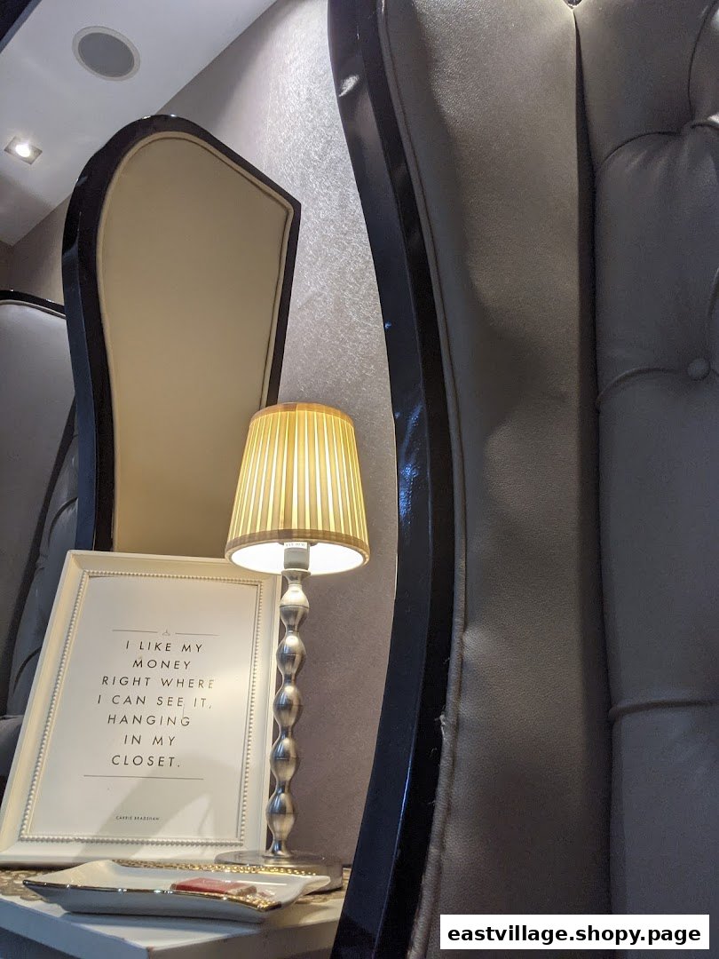 A stylish interior detail featuring a framed quote, a lamp, and elegant salon seating.
