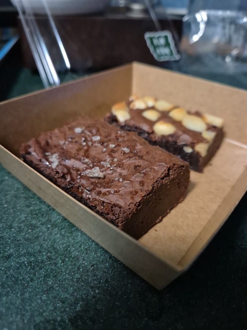 Two delicious brownies, one with sea salt and one with nuts, presented in a brown paper box.