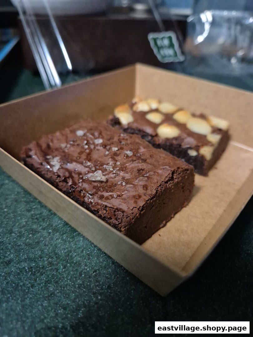 Two delicious brownies, one with sea salt and one with nuts, presented in a brown paper box.