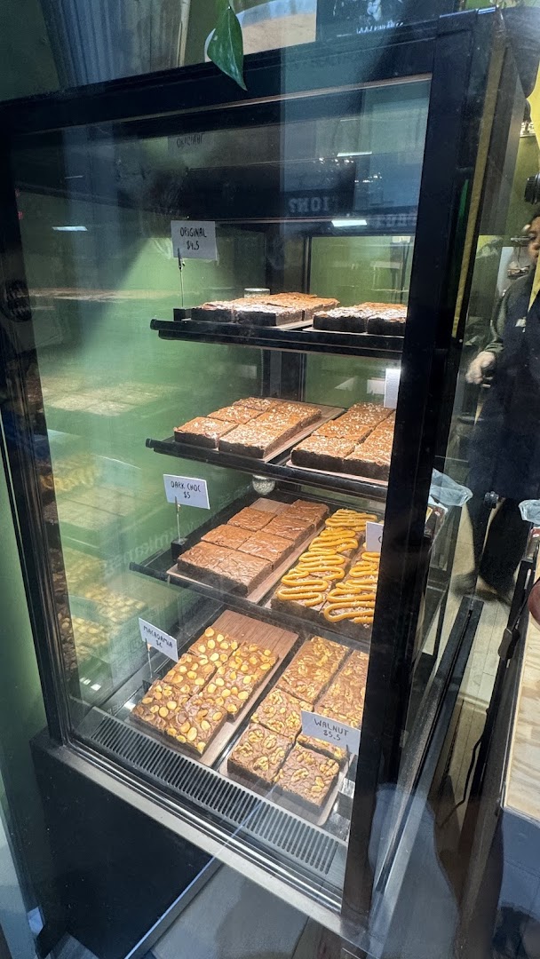 A display case showcasing a variety of delicious brownies and baked goods at Kin Kán.