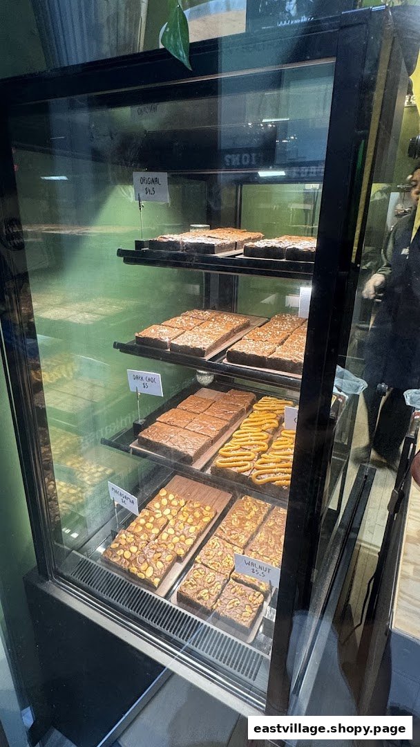 A display case showcasing a variety of delicious brownies and baked goods at Kin Kán.