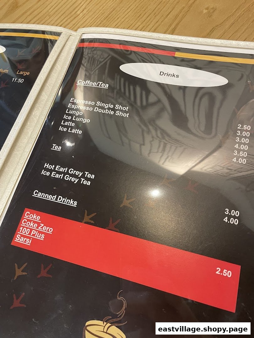 A close-up view of the drinks section of a cafe's menu, featuring coffee, tea, and canned beverages.