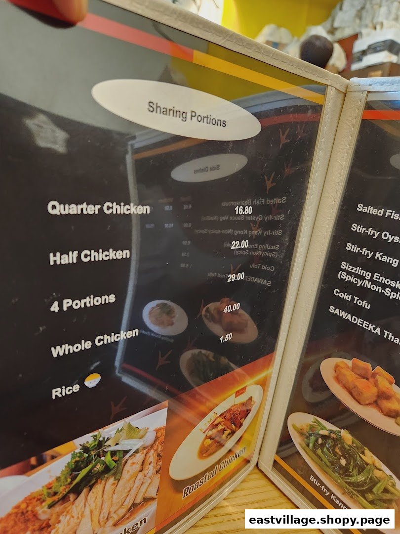 A close-up view of a menu displaying chicken rice and other Thai-inspired dishes.
