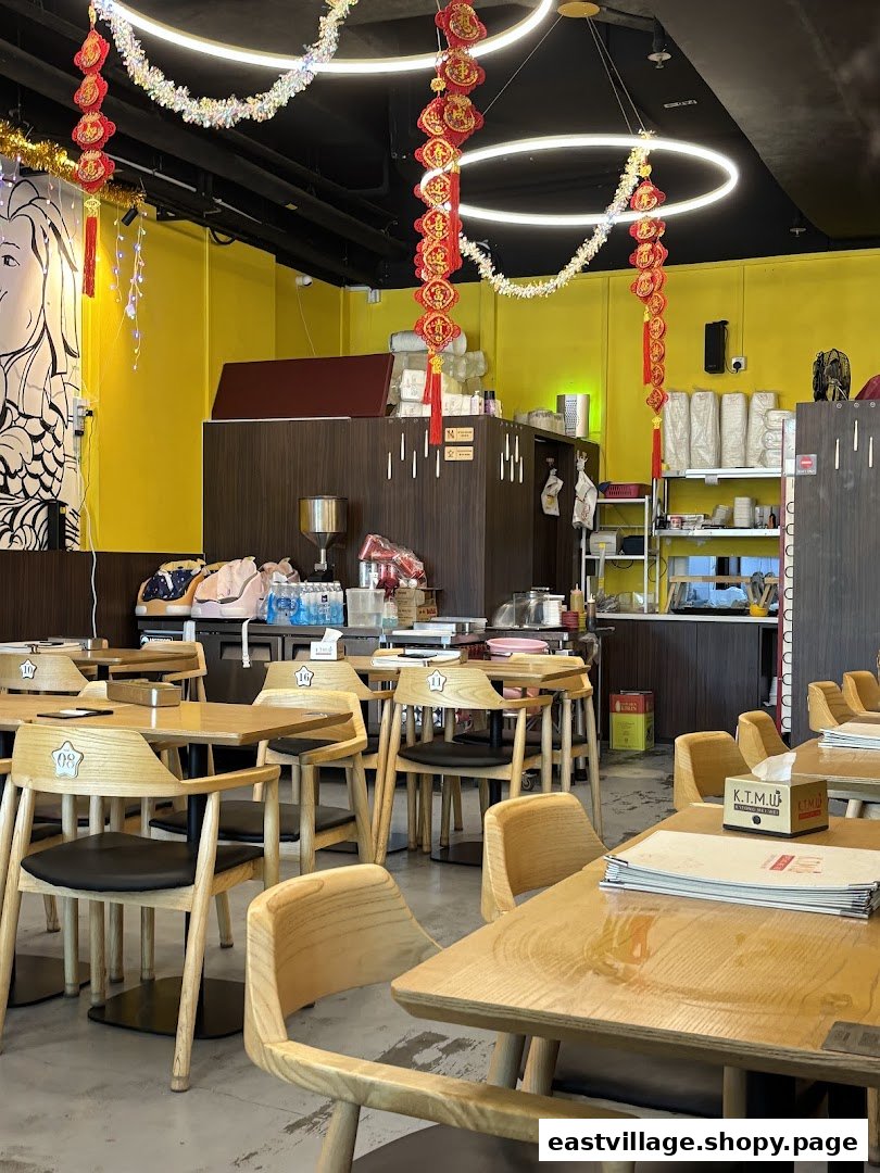 Interior view of KTMW Katong Mei Wei chicken rice tea-cafe with wooden tables and chairs.