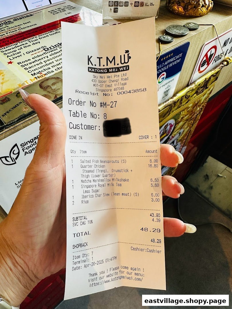 A hand holds a detailed receipt from KTMW Katong Mei Wei, listing various food and drink items with prices.