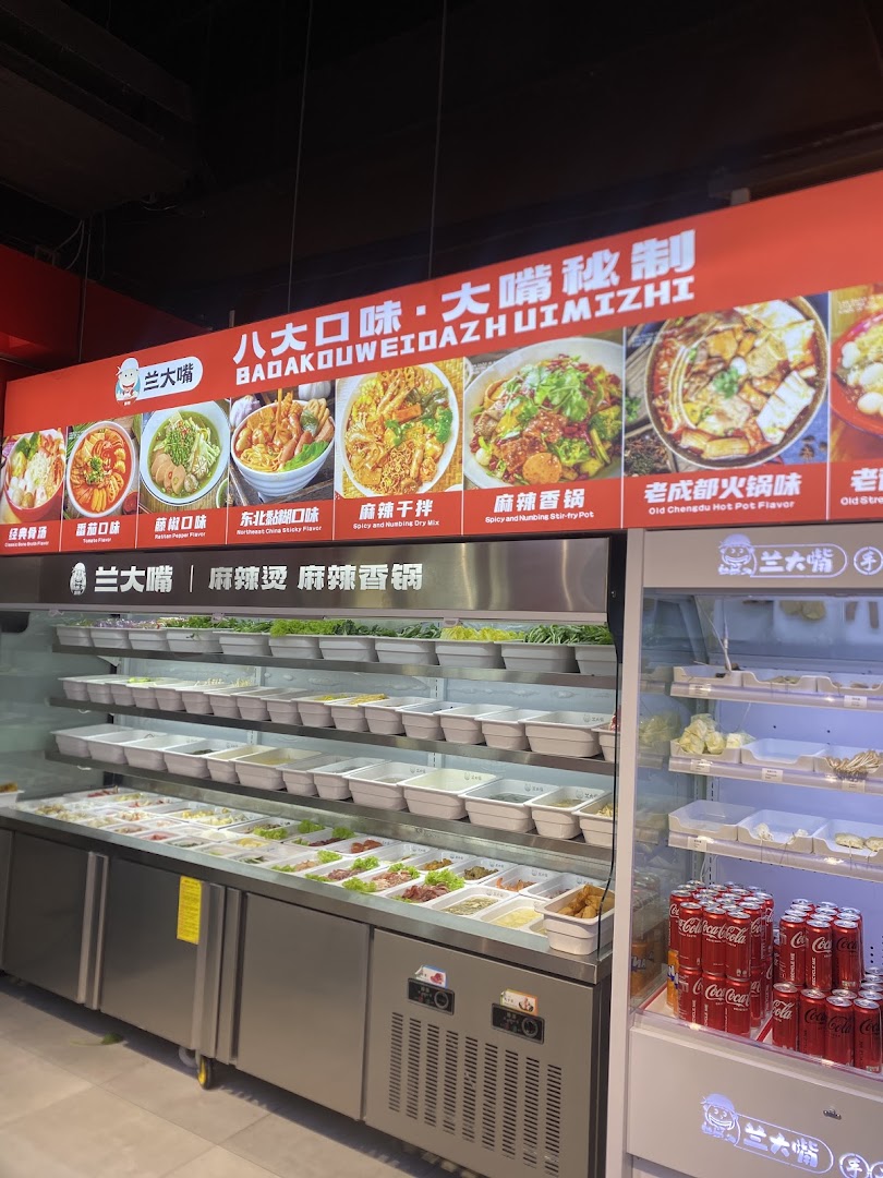 An interior view of Lan Da Zui, showcasing a fresh ingredient bar and a vibrant menu board.