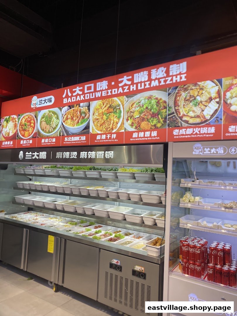 An interior view of Lan Da Zui, showcasing a fresh ingredient bar and a vibrant menu board.