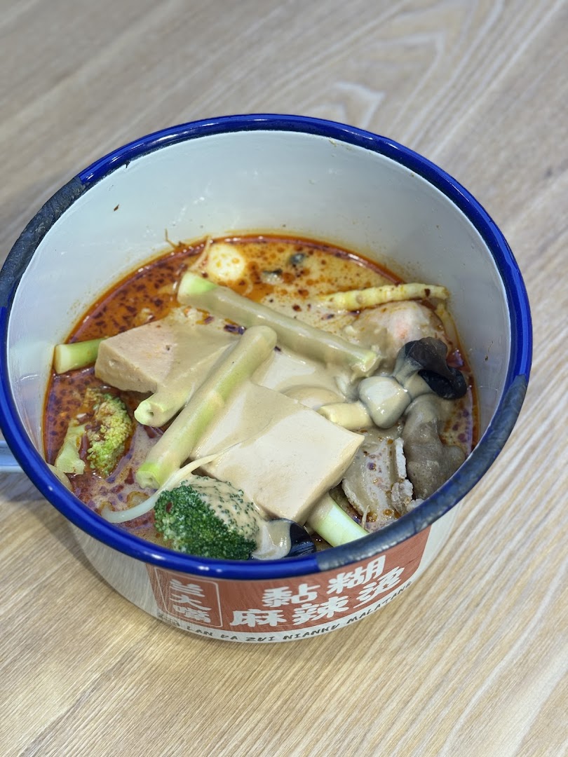 A close-up of a delicious bowl of Malatang with various ingredients in a traditional enamel bowl.