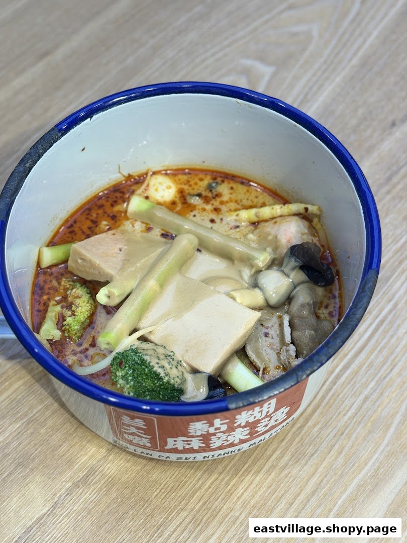 A close-up of a delicious bowl of Malatang with various ingredients in a traditional enamel bowl.