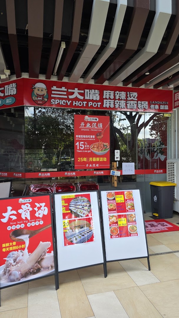 The vibrant red storefront of Lan Da Zui, a spicy hot pot restaurant, with promotional signs.