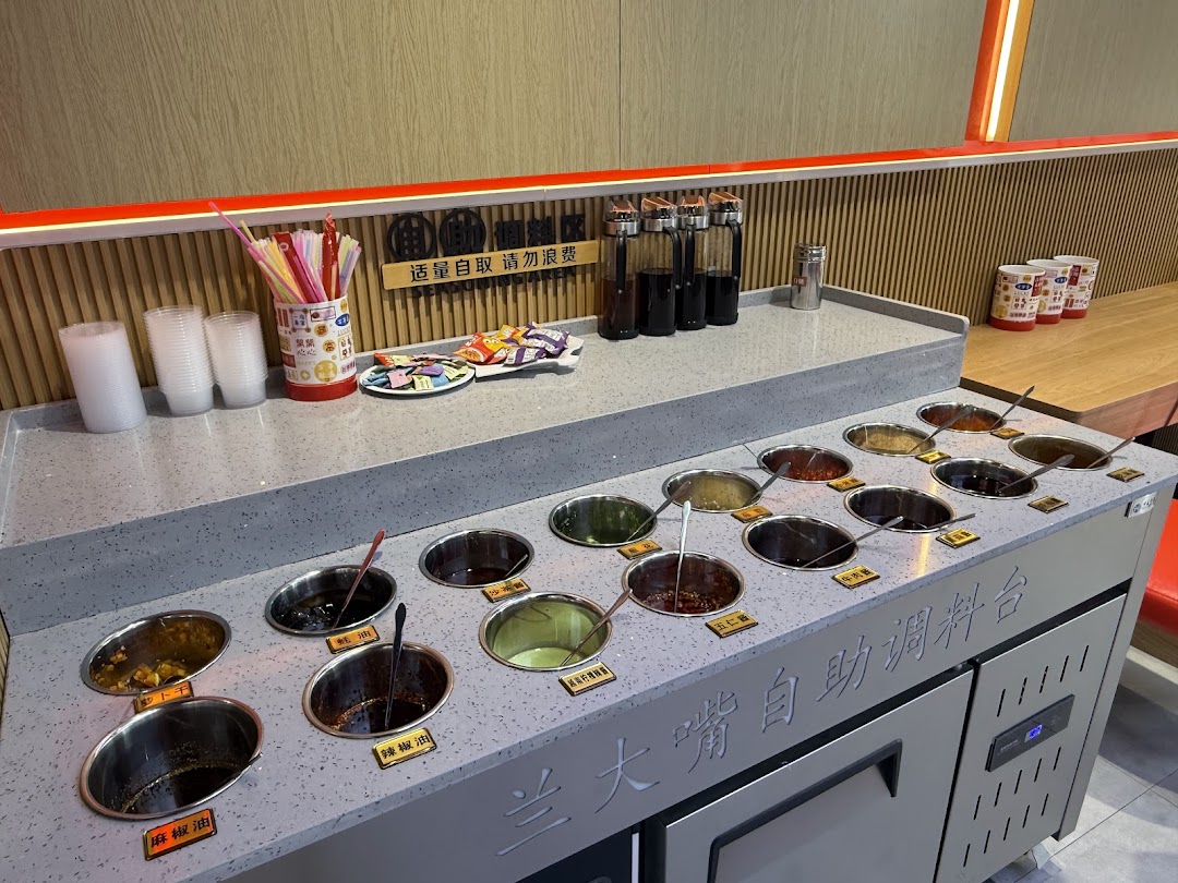 A self-service condiment bar at Lan Da Zui, offering various sauces and toppings.