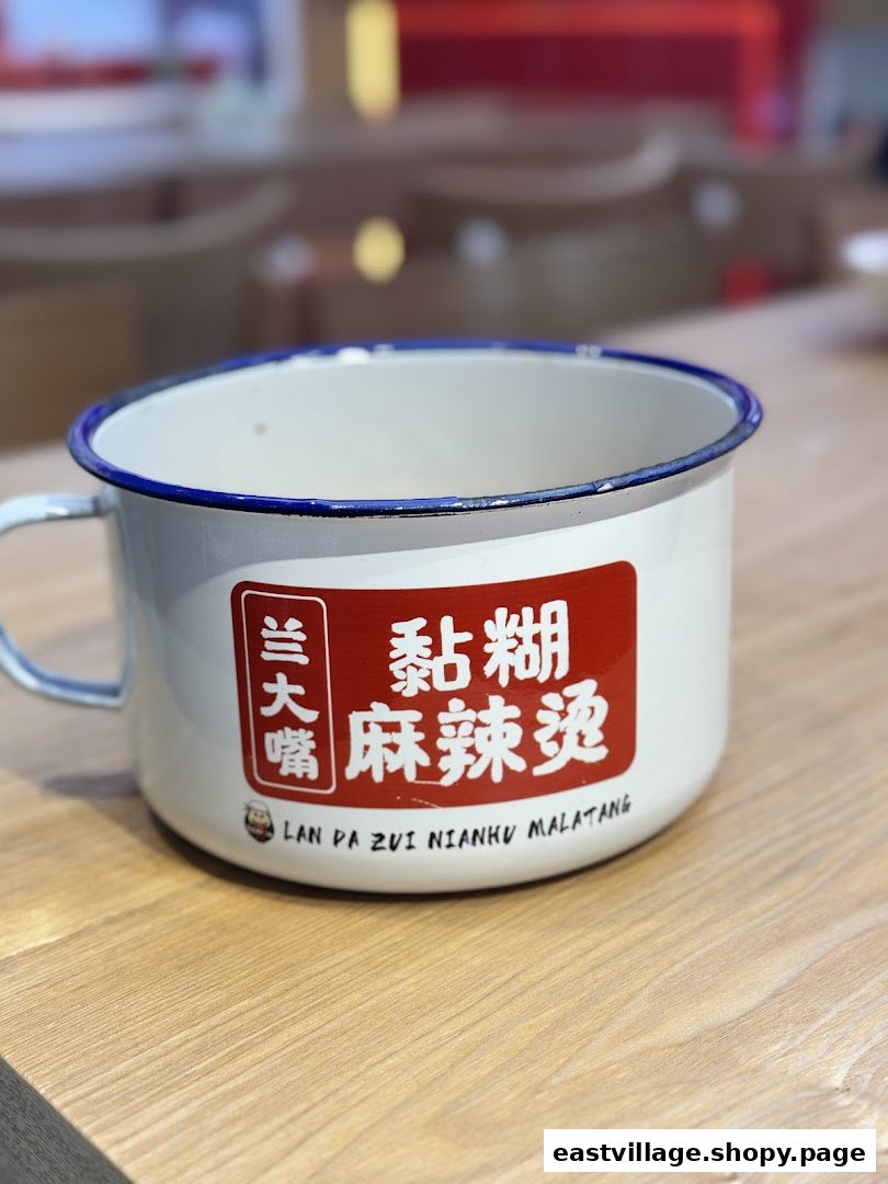 An enamel mug featuring the shop's name 'Lan Da Zui' and 'Nianhu Malatang' branding.