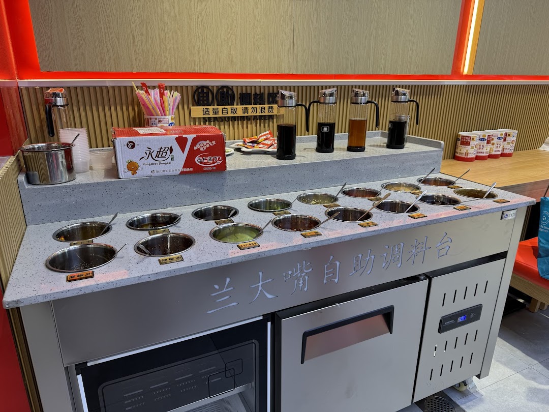 A self-service condiment bar at Lan Da Zui, featuring various sauces and toppings for customers.